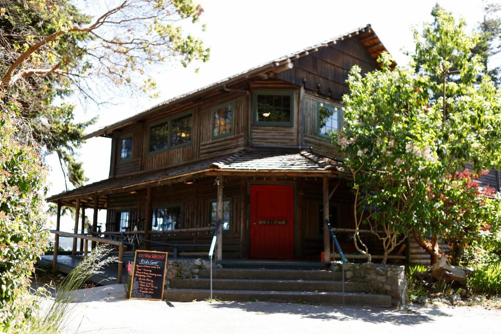 a large wooden house with a red door at Captain Whidbey in Coupeville