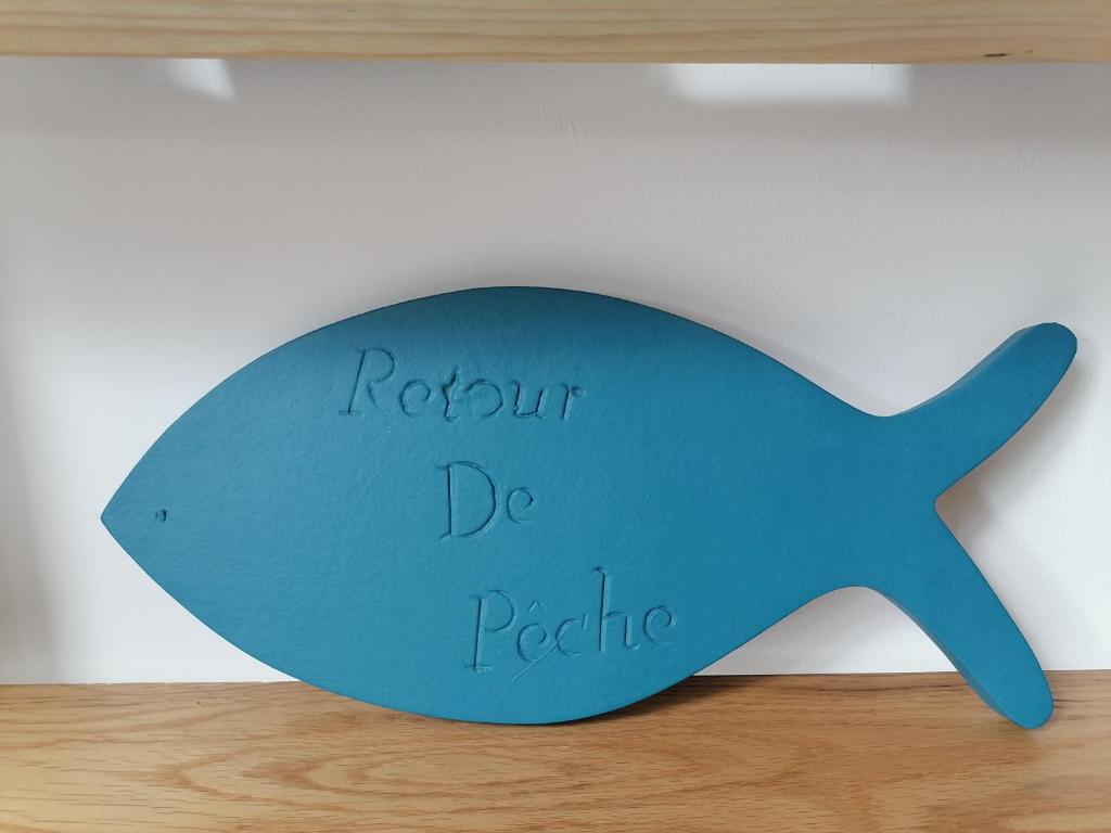 a blue fish sign on a shelf with the words return de peoria at Aux Caboteurs in Arzal