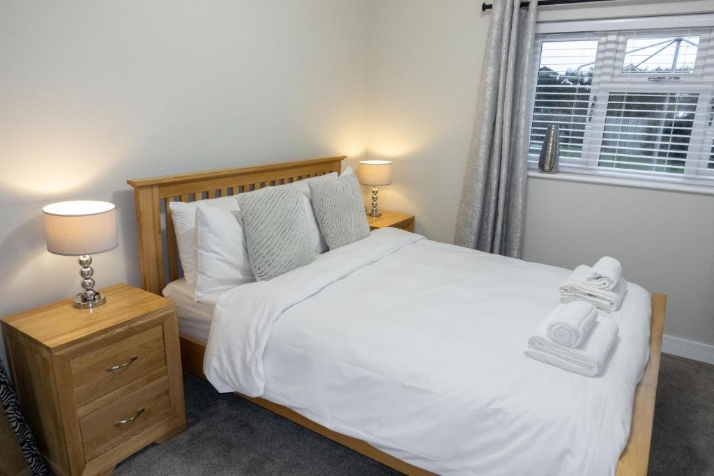 sypialnia z łóżkiem, 2 lampami i oknem w obiekcie Contemporary new build with parking & garden in central location w mieście Hereford