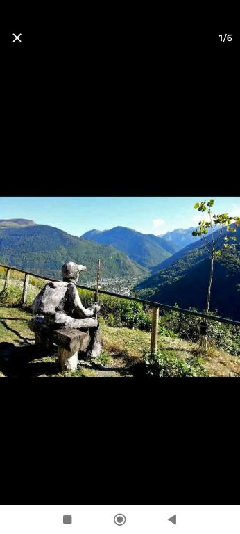 un lion en pierre assis sur une clôture donnant sur les montagnes dans l'établissement Studio cosy luchon, à Luchon