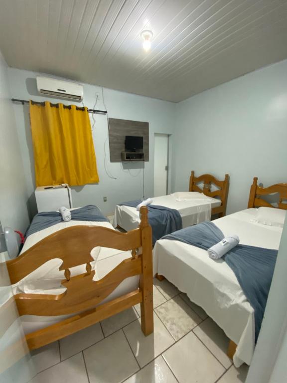 ein Krankenhauszimmer mit 2 Betten und einem TV in der Unterkunft Pousada Capim Dourado Jalapão São Felix TO in São Félix do Tocantins