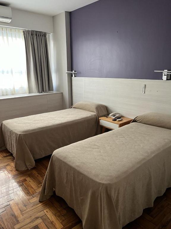 a hotel room with two beds and a window at Columbia Palace Hotel in Buenos Aires