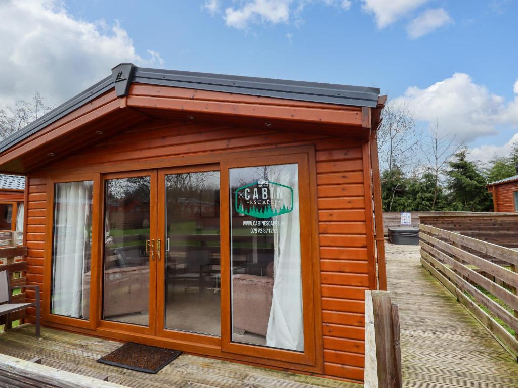 a small cabin with a solar roof on a deck at Toucana in Morpeth