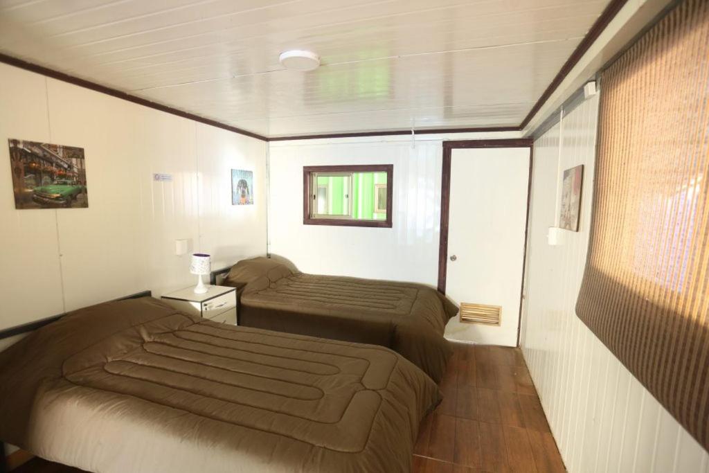 塔爾卡的住宿－hostal ibiza，一间小卧室,配有两张床和窗户