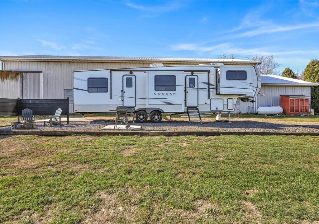 una caravana estacionada frente a una casa en Cozy 2-Guest RV on Nature Farm, en Pine Grove