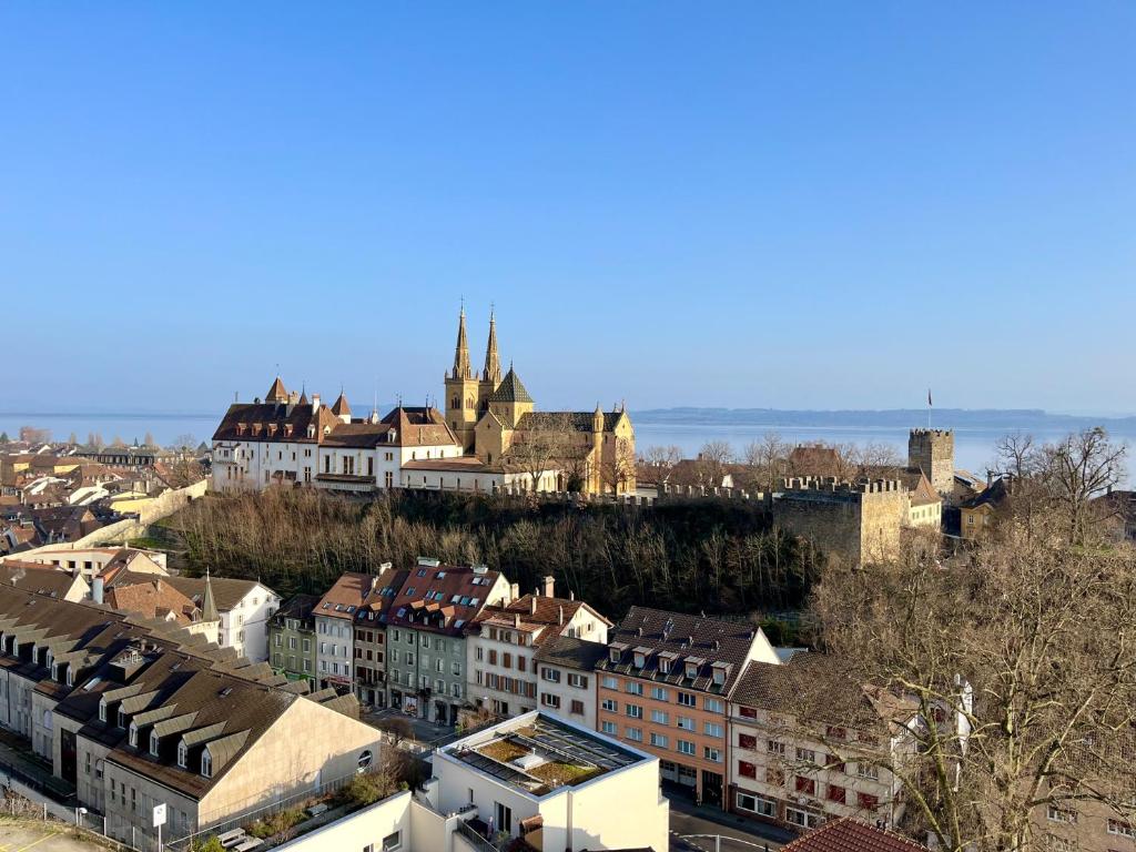 uma vista para uma cidade com edifícios e uma igreja em L’Ecluse em Neuchâtel