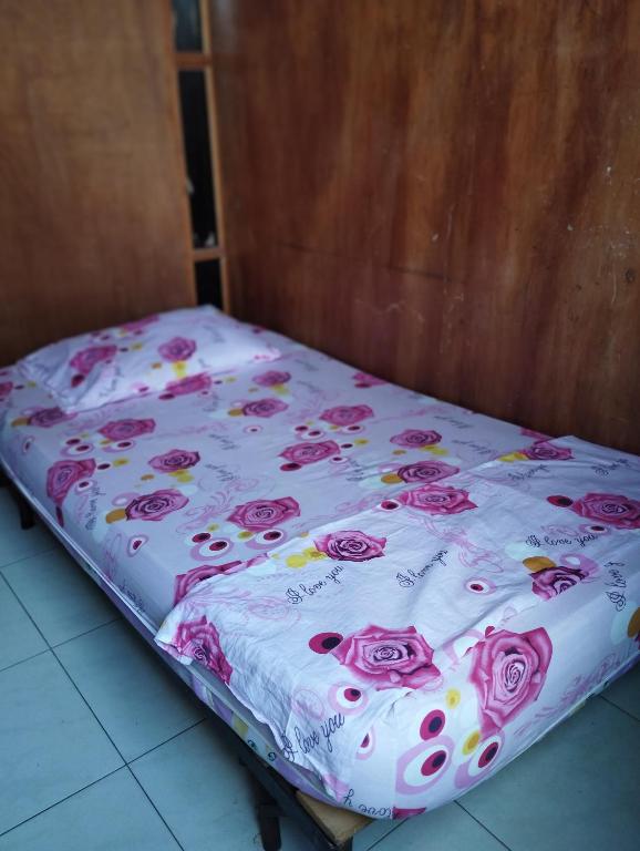 un letto con un lenzuolo di rose sopra di Apartamentos Ganen a Cartagena de Indias