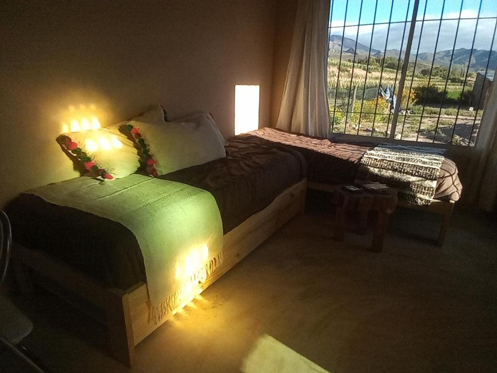 a bedroom with two beds and a window with a view at Cabaña Huacalera in Huacalera