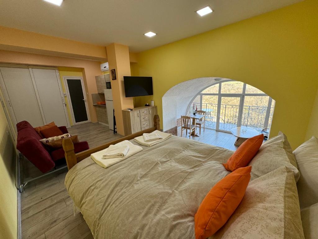 Apartment Happy Place 2 في فيليكو ترنوفو: غرفة نوم بسرير كبير وغرفة معيشة