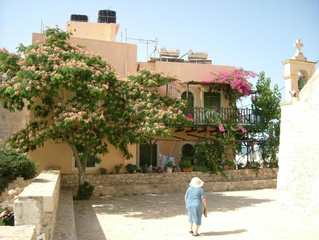 een vrouw die voor een gebouw met bloemen loopt bij CretanHouse in Myrtos