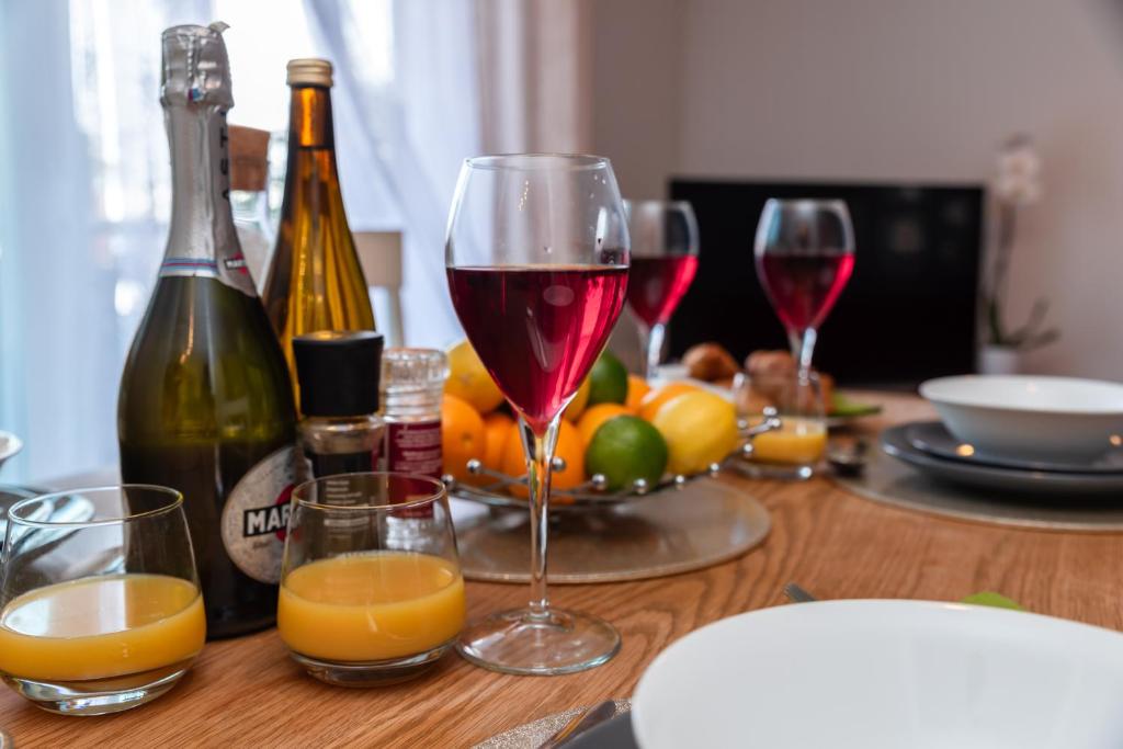 two glasses of wine sitting on a table with fruit at Accessible 2 bedrooms flat + P in Southampton