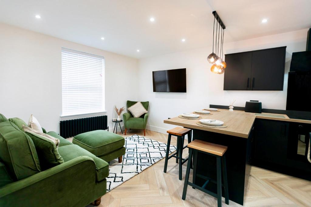 een woonkamer met een groene bank en een tafel bij Skegness Luxury 2 bedroom accommodation , sleeps 6 people in Lincolnshire