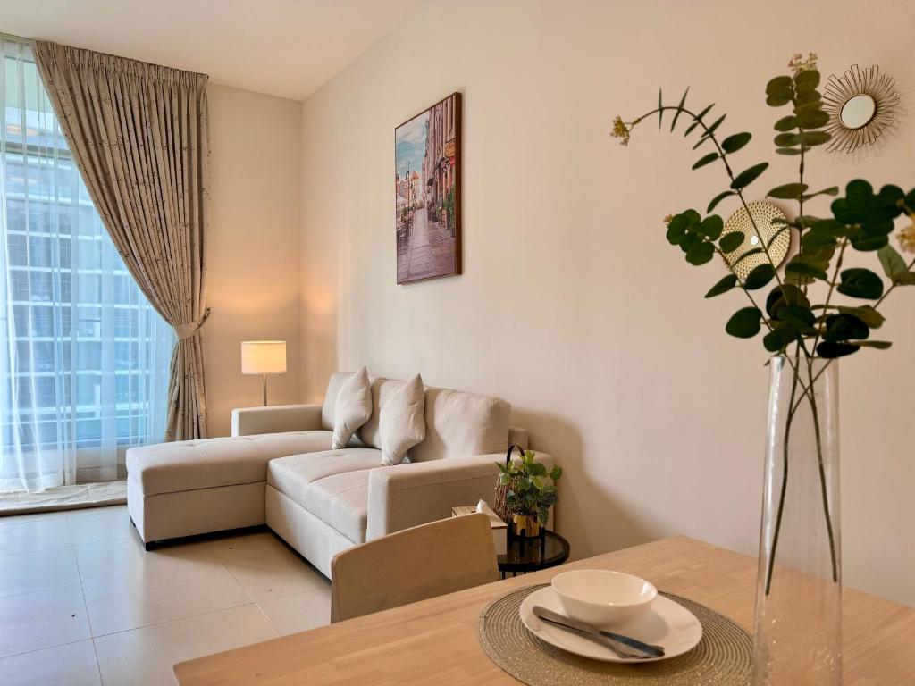 uma sala de estar com um sofá e uma mesa em CityVibesDxb em Dubai