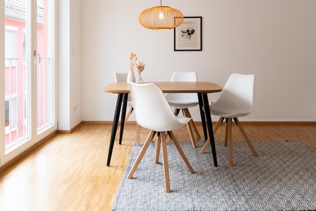 a dining room with a wooden table and white chairs at Altstadt Apartment 2 Zimmer am Weibermarkt in Reutlingen