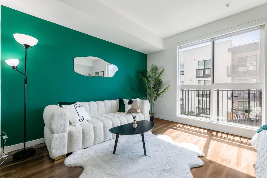 a living room with a white couch and a green wall at Luxury Home in Hollywood with Pool I Gym I Free Parking in Los Angeles