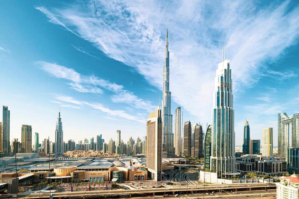 een uitzicht op de skyline van Dubai op een zonnige dag bij LUXE Vacation Homes - Luxury 2BR Apartment - Burj Khalifa View & Direct Dubai Mall Access in Dubai