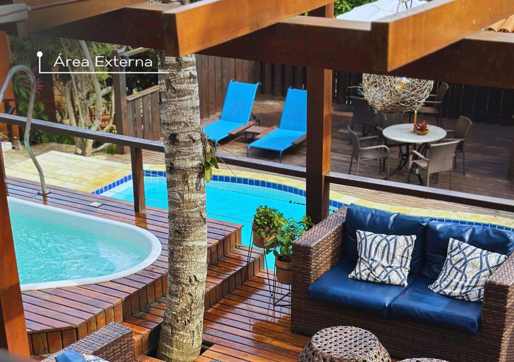 un patio con bañera de hidromasaje, mesa y sillas en Calador Búzios Hotel, en Búzios