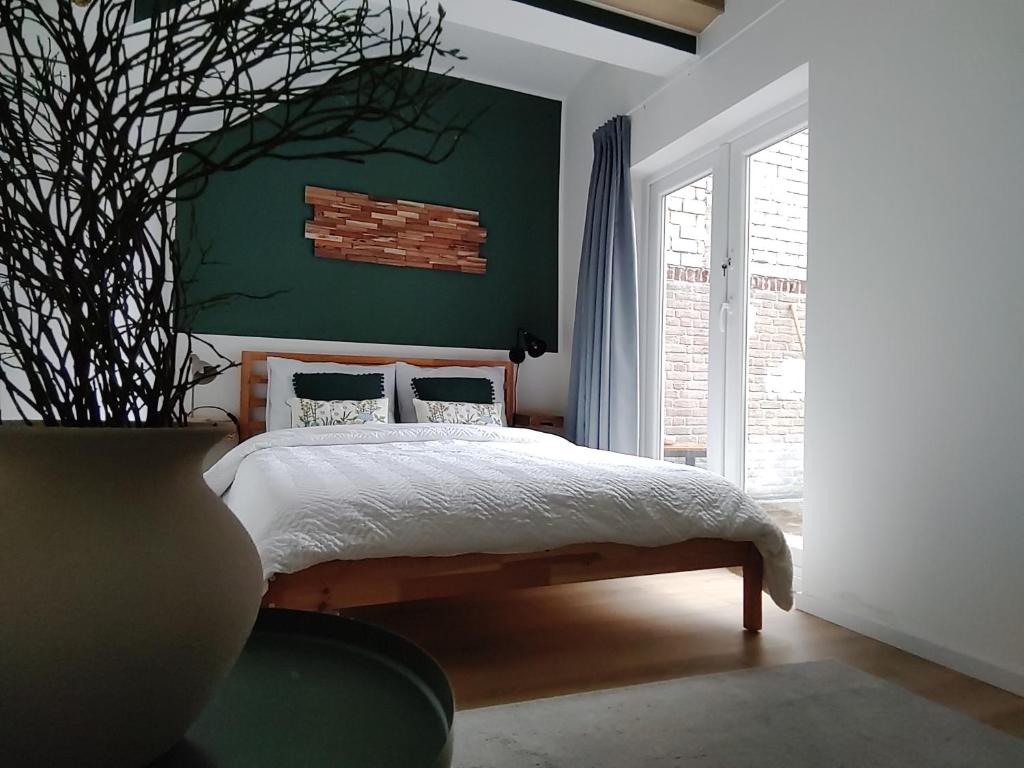 1 dormitorio con cama y pared verde en Maya sweet rooms, en Heerlen