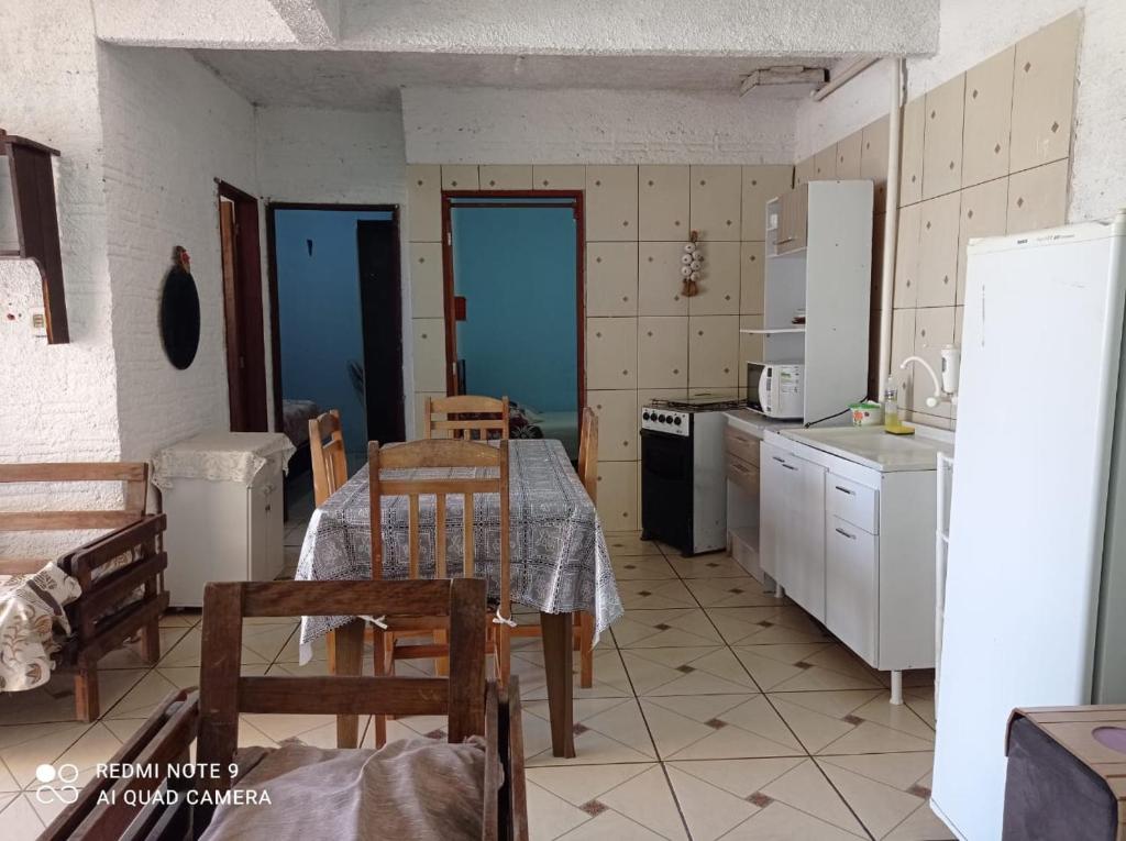 a kitchen with a table and chairs in a kitchen at Casa com piscina in Rio Grande