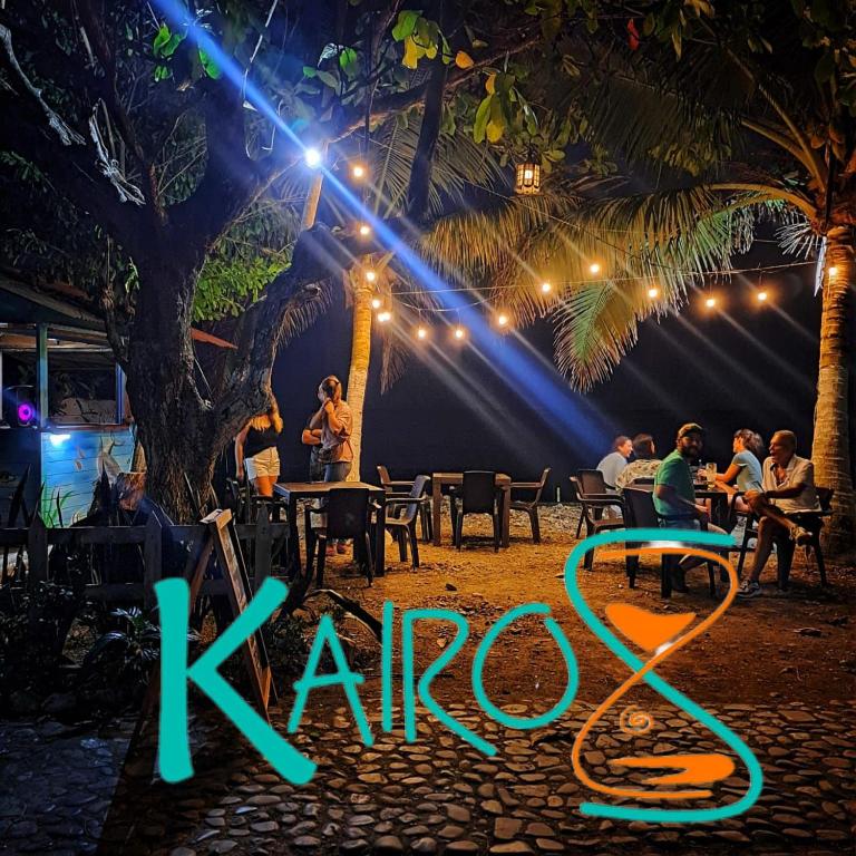 a group of people sitting at tables in a restaurant at night at Hospedaje Kairos Capurgana in Capurganá