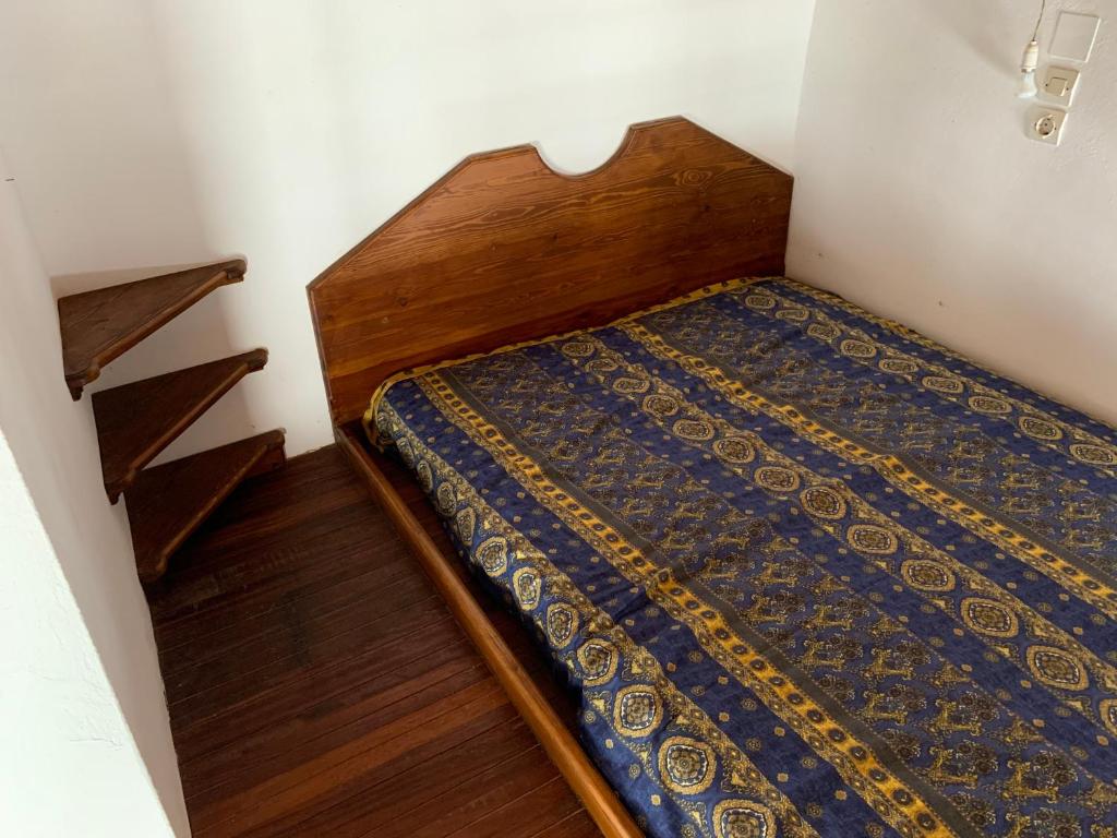 a bedroom with a bed with a wooden headboard at Σπιτι Χωρα Πατμου in Patmos