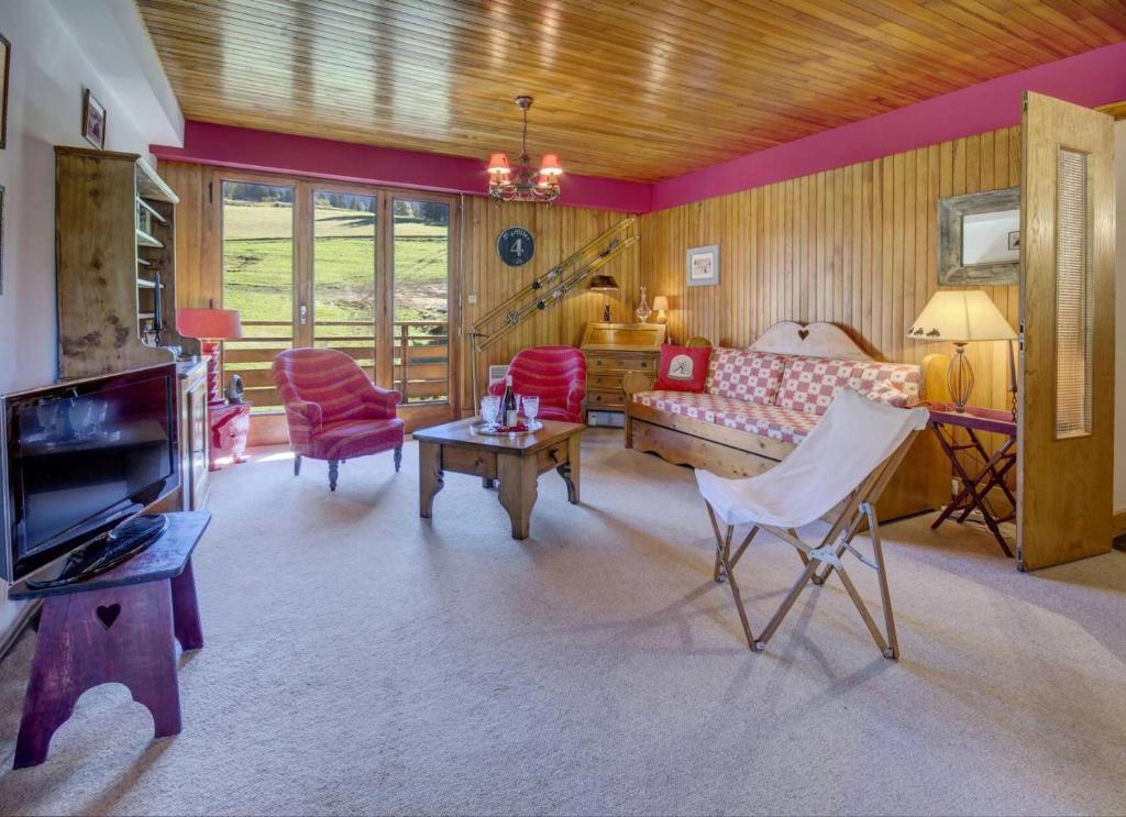 un salon avec un canapé et une télévision dans l'établissement Résidence Le Val D'or - Appartement Val d'Or - 4 Personnes - Les Gets MAE-4061, aux Gets