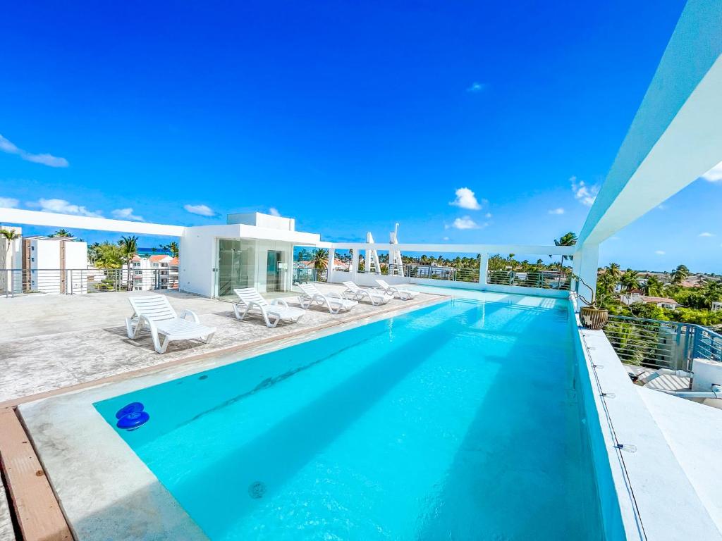 a swimming pool on the roof of a house at DUCASSI SUITE Sol Karibe SUITES STUDIOS TROPICANA Rooftop POOL WiFi Beach & SPA in Punta Cana