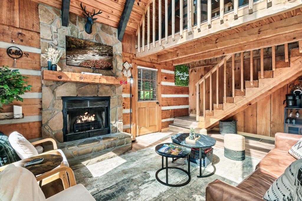 a living room with a fireplace in a log cabin at NEW! Black Bear Chalet Getaway with Games, Hot Tub, RnR, Fun in Sevierville