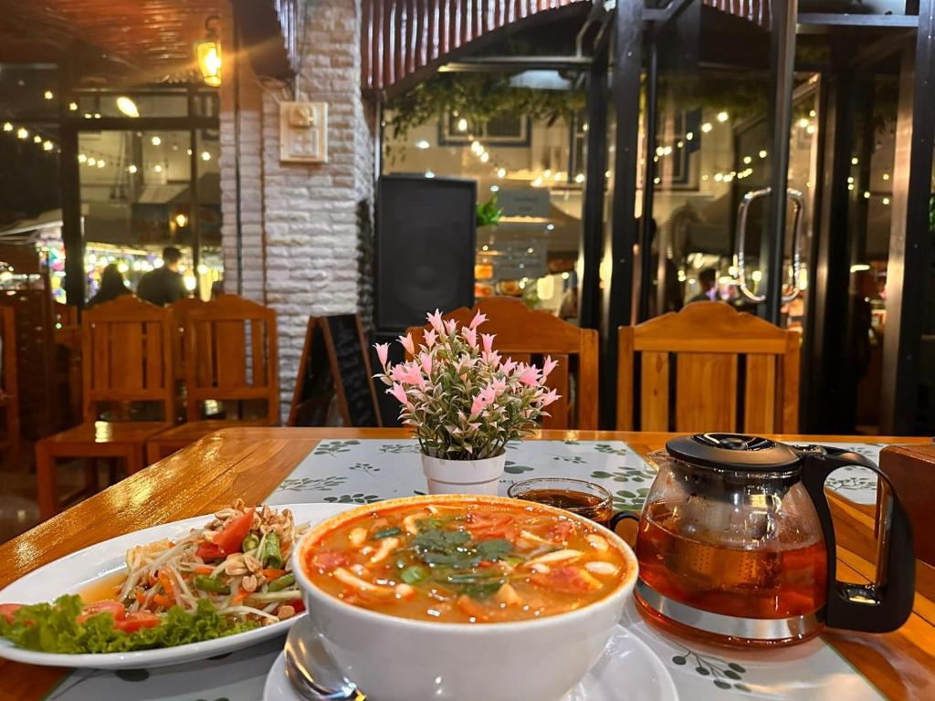 una ciotola di zuppa e un piatto di cibo su un tavolo di BT hotel Kata Beach a Kata Beach