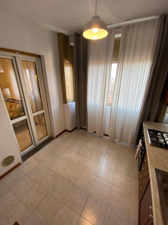 ein leeres Zimmer mit einer Küche mit Glastüren in der Unterkunft Hlux OI ₐffᵢₜₜₐCₐₘₑᵣₑ in Piacenza