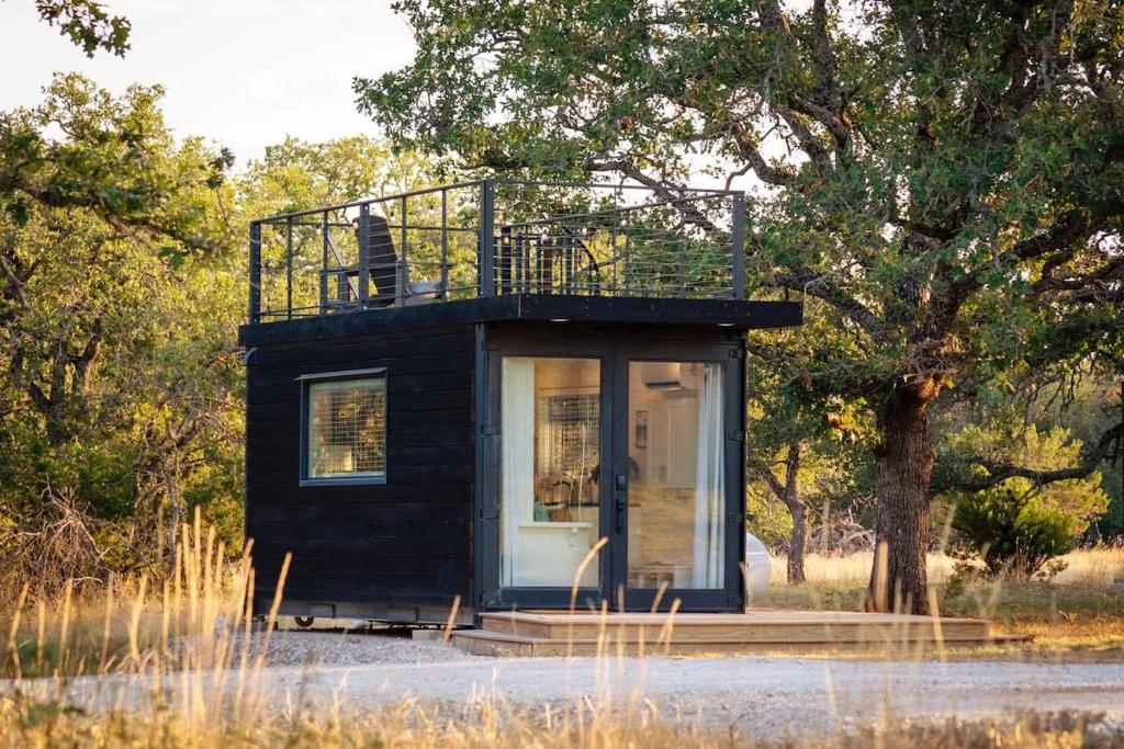 a tiny house with a balcony on top of it at New! Luxury Shipping Container The Desert Escape in Fredericksburg