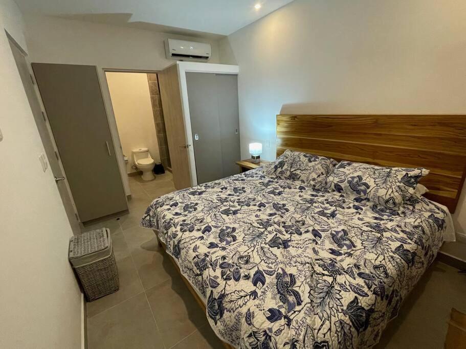 um quarto com uma cama com um edredão azul e branco em 2Bdr Condo - Los Delfines Golf & Country Club - Large Patio - Beach of Playa Tambor - 24 hrs security em Pochote