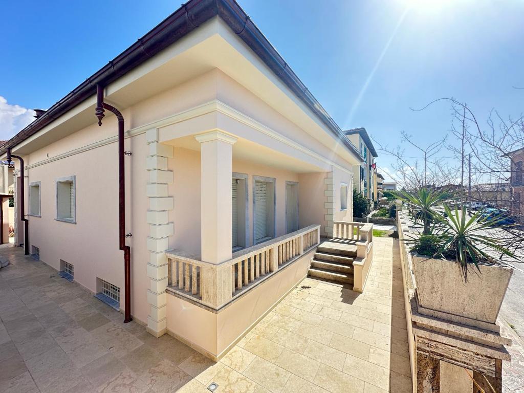 ein Haus mit einer Veranda und einem Balkon in der Unterkunft Luxury Villa with SPA near the Beach in Querceta