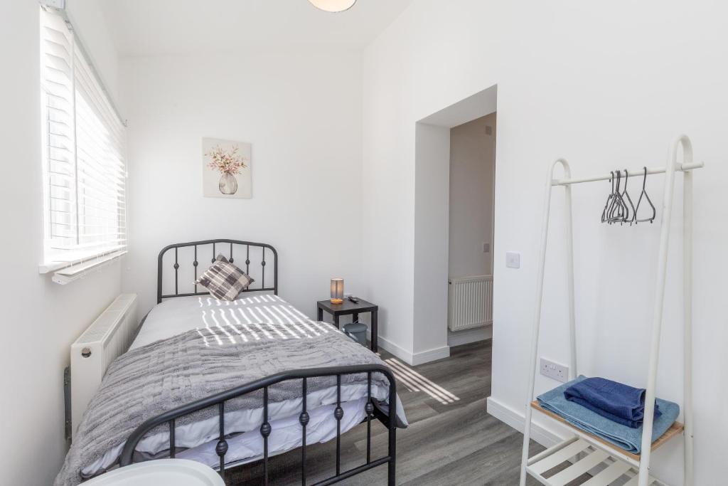 um quarto branco com uma cama e uma janela em 20 Leys Road rooms 1 - 4 em Wellingborough