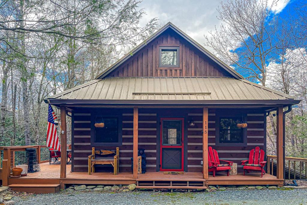 una cabina in legno con sedie rosse e bandiera di Bear Feet Retreat a Banner Elk