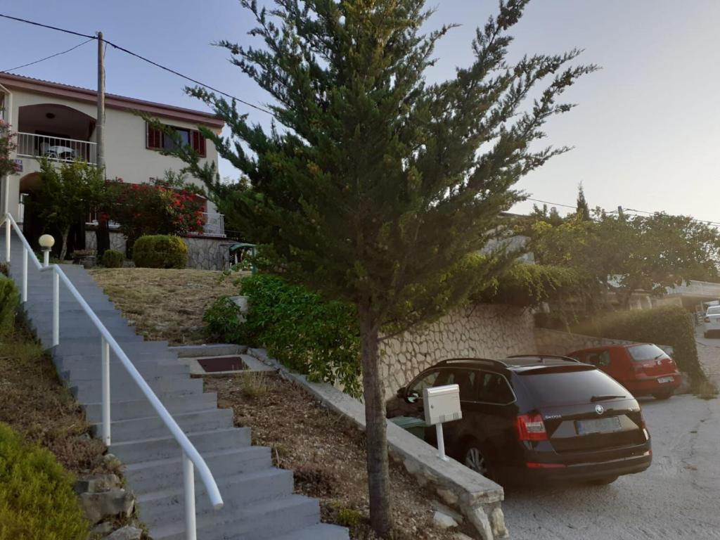 ein Auto, das neben einem Baum in einer Einfahrt parkt in der Unterkunft Apartment Beach View in Kruševo
