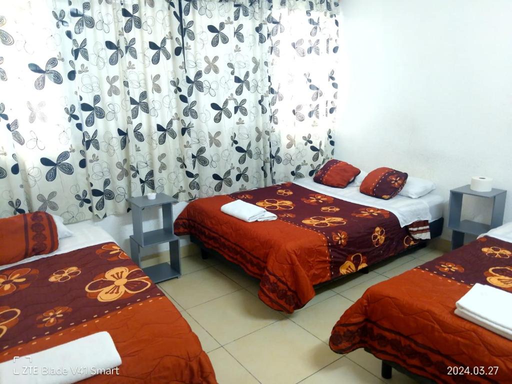 2 camas en una habitación con cortinas y cortinas en Alojamiento GAMA en Ciudad de México