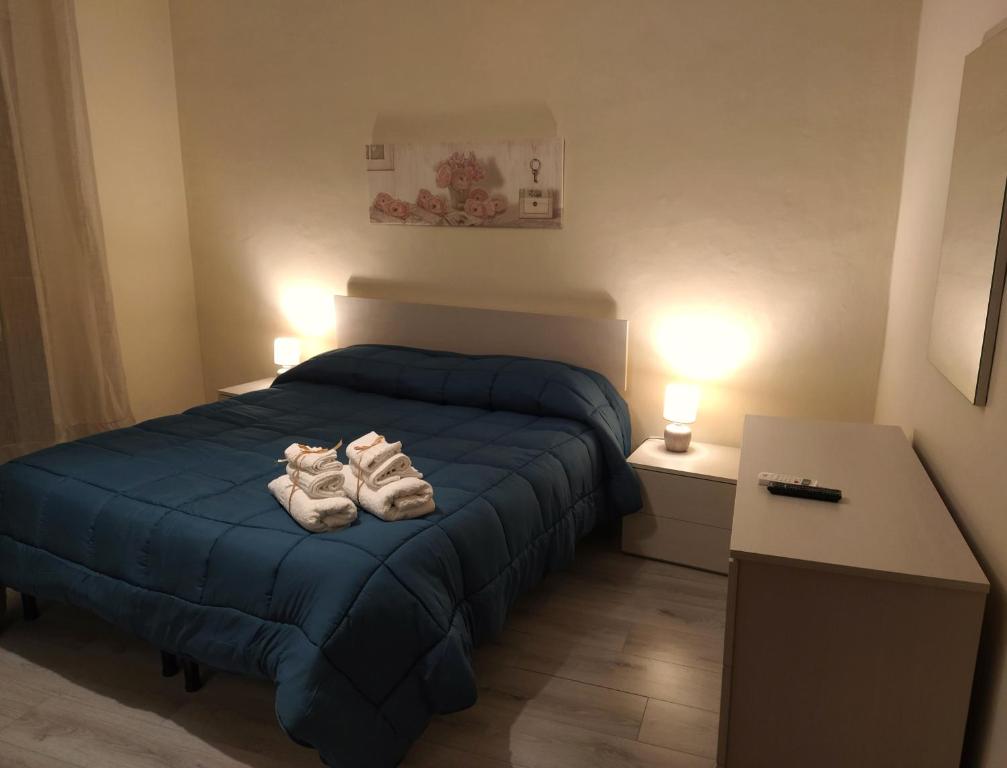 una camera da letto con un letto blu e asciugamani di Il Portoncino ^ Apt.^ a Agrigento