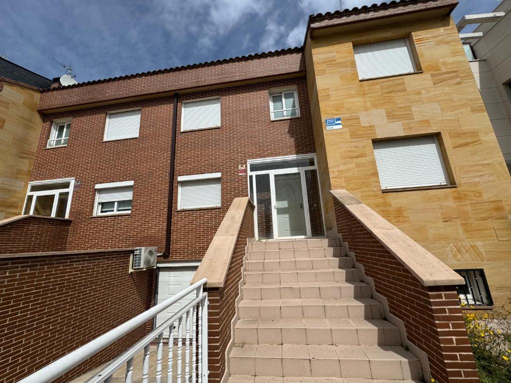 a brick building with stairs in front of it at Chalet IFema 5 Habitaciones 4 baños, parking free in Madrid