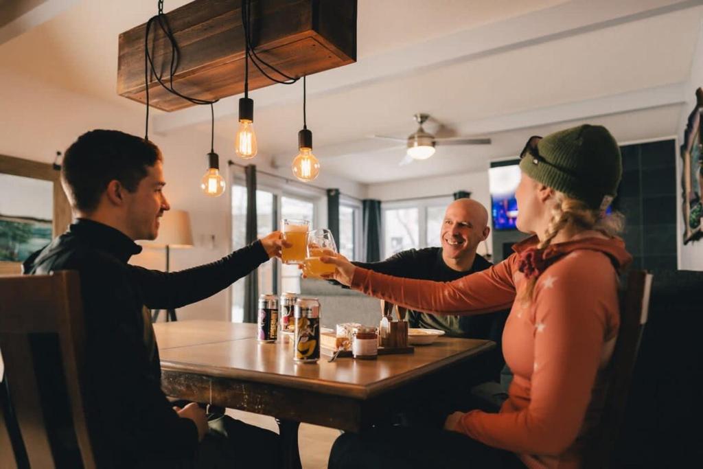 un grupo de personas sentadas alrededor de una mesa bebiendo cerveza en Beautiful Condo 3-Eleven at Tremblant, en Mont-Tremblant