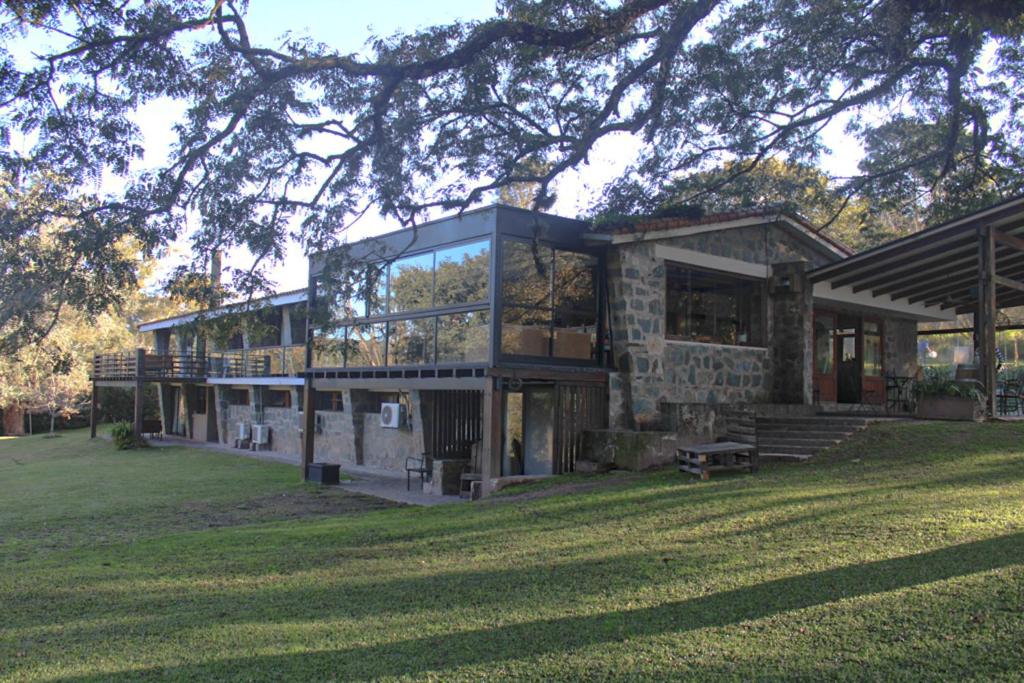a large house with glass windows on a lawn at La Pedra Hotel Boutique, Raco in Raco