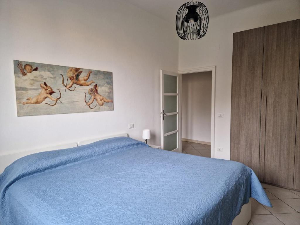 a bedroom with a blue bed and a painting on the wall at HomeLame 57 in Bologna