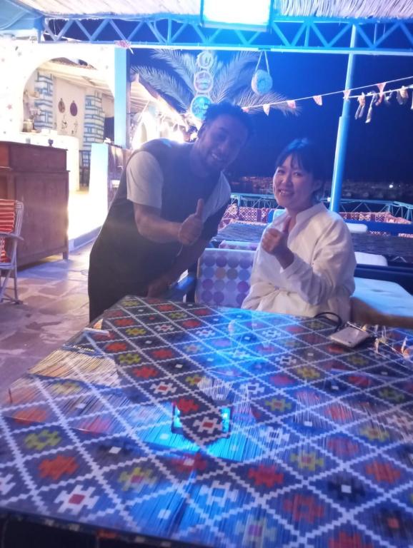 ShellalEndo Mando的站在桌子前的男人和女人