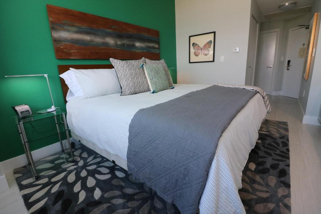 a bedroom with a large bed with a green wall at Renovated 21st Floor Private Unit located in Coconut Grove Hotel in Miami