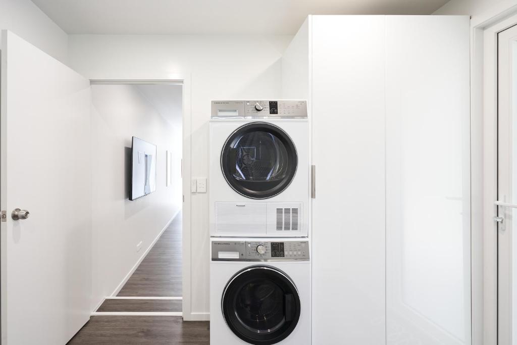 uma lavandaria com duas máquinas de lavar e secar roupa em Modern Home Near Town em Dunedin