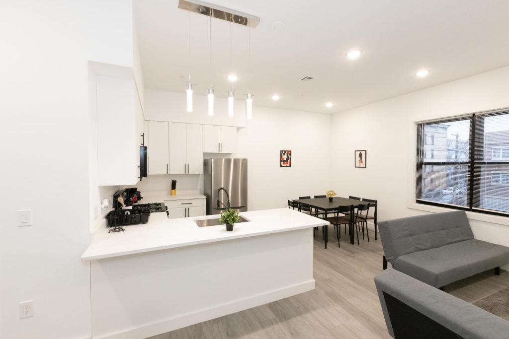 a kitchen and living room with a couch and a table at Modern Contemporary 2-Bed Apt Close to NYC in Bayonne