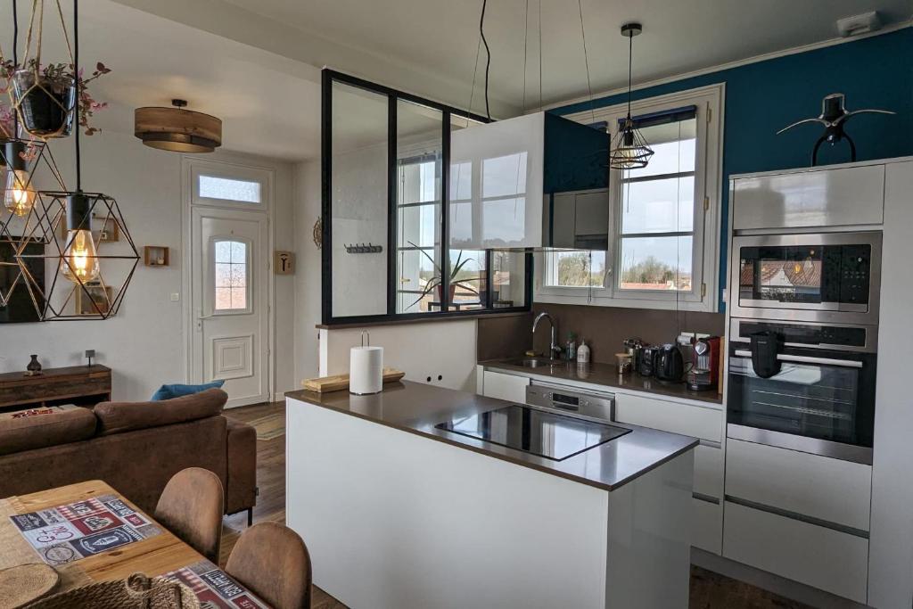 - une cuisine avec un îlot blanc dans le salon dans l'établissement Family cocoon by the sea, à La Tranche-sur-Mer