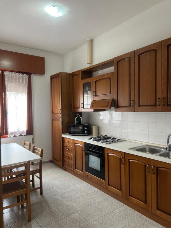 een keuken met houten kasten en een tafel en een tafel bij Villa Cattel in Lido di Jesolo