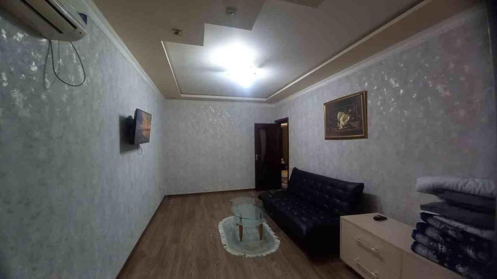 sala de estar con sofá y mesa en Apartment for guests in the centre of Tashkent city en Tashkent