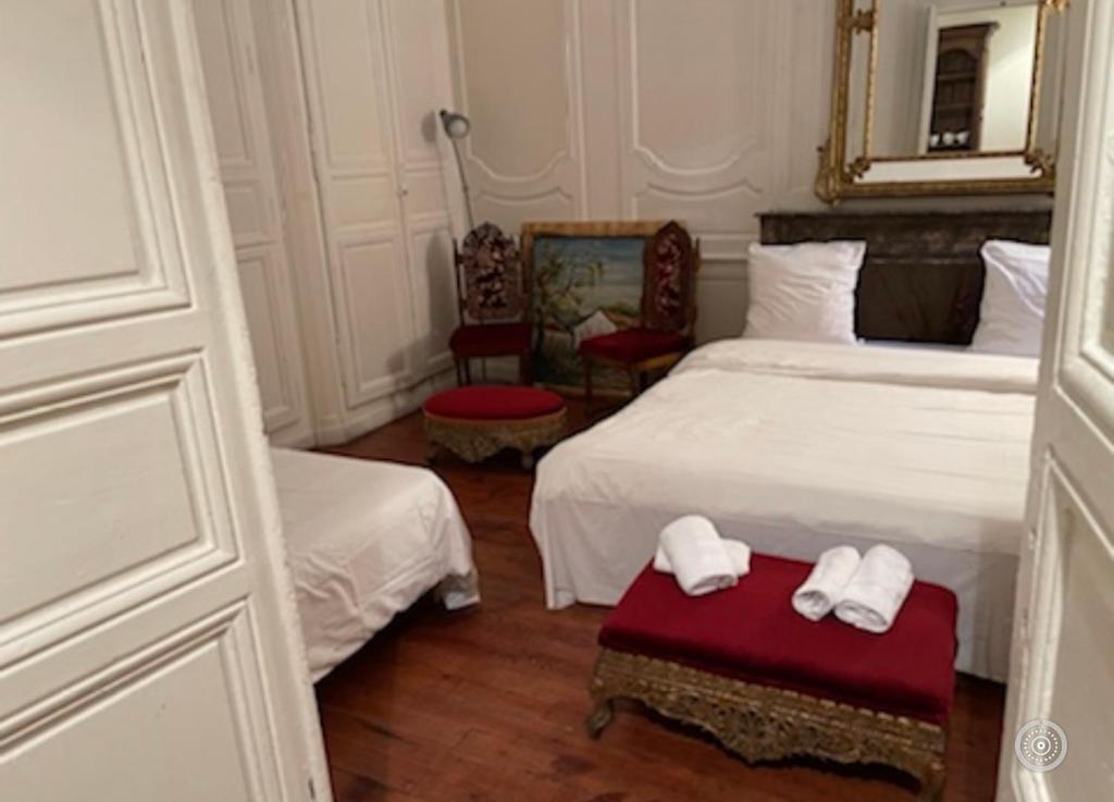 - une chambre avec 2 lits, 2 chaises et un miroir dans l'établissement T2 devise appartement center ville, à Bordeaux